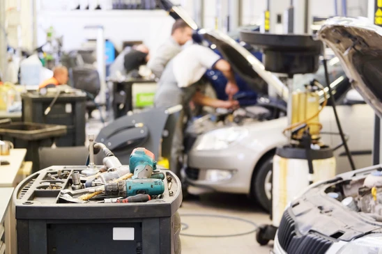 Atelier de réparation automobile avec véhicule surélevé sur pont élévateur hydraulique bleu