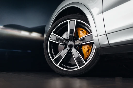 Intérieur d'entrepôt de pièces automobiles avec étagères métalliques rouges contenant des composants électriques de véhicules