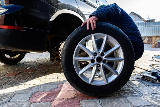 Intérieur d'entrepôt de pièces automobiles avec étagères métalliques rouges contenant des composants électriques de véhicules